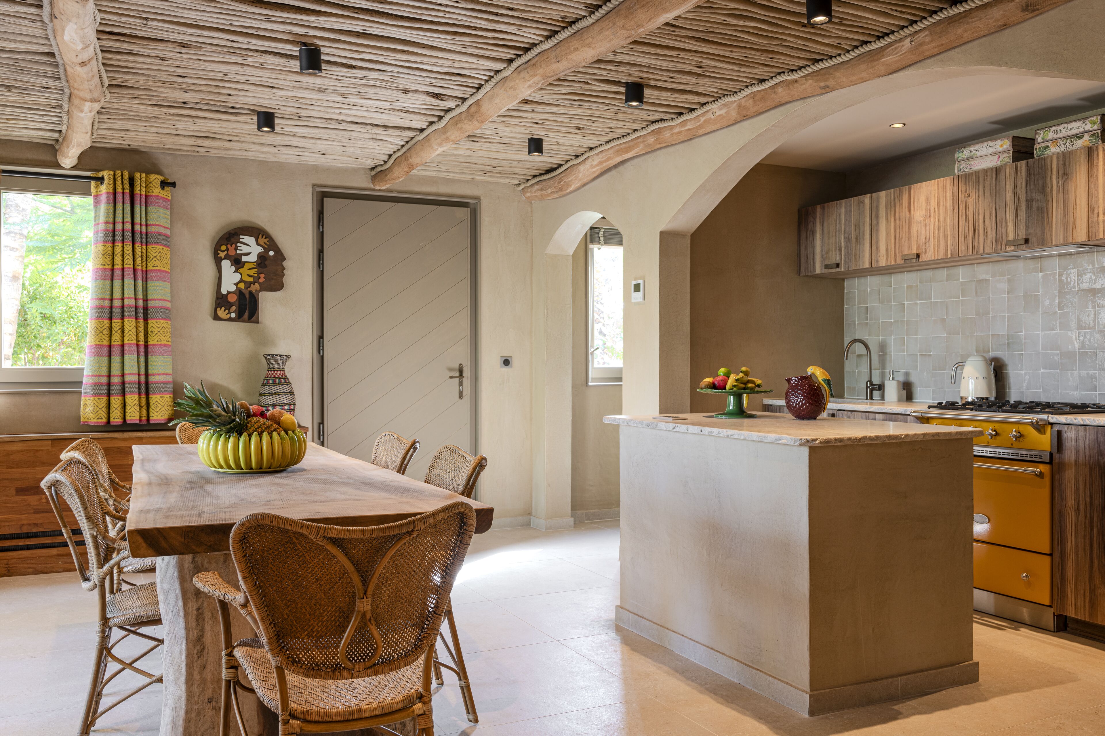 Cozinha espaçosa com ilha central, armários de madeira e painel de azulejos.