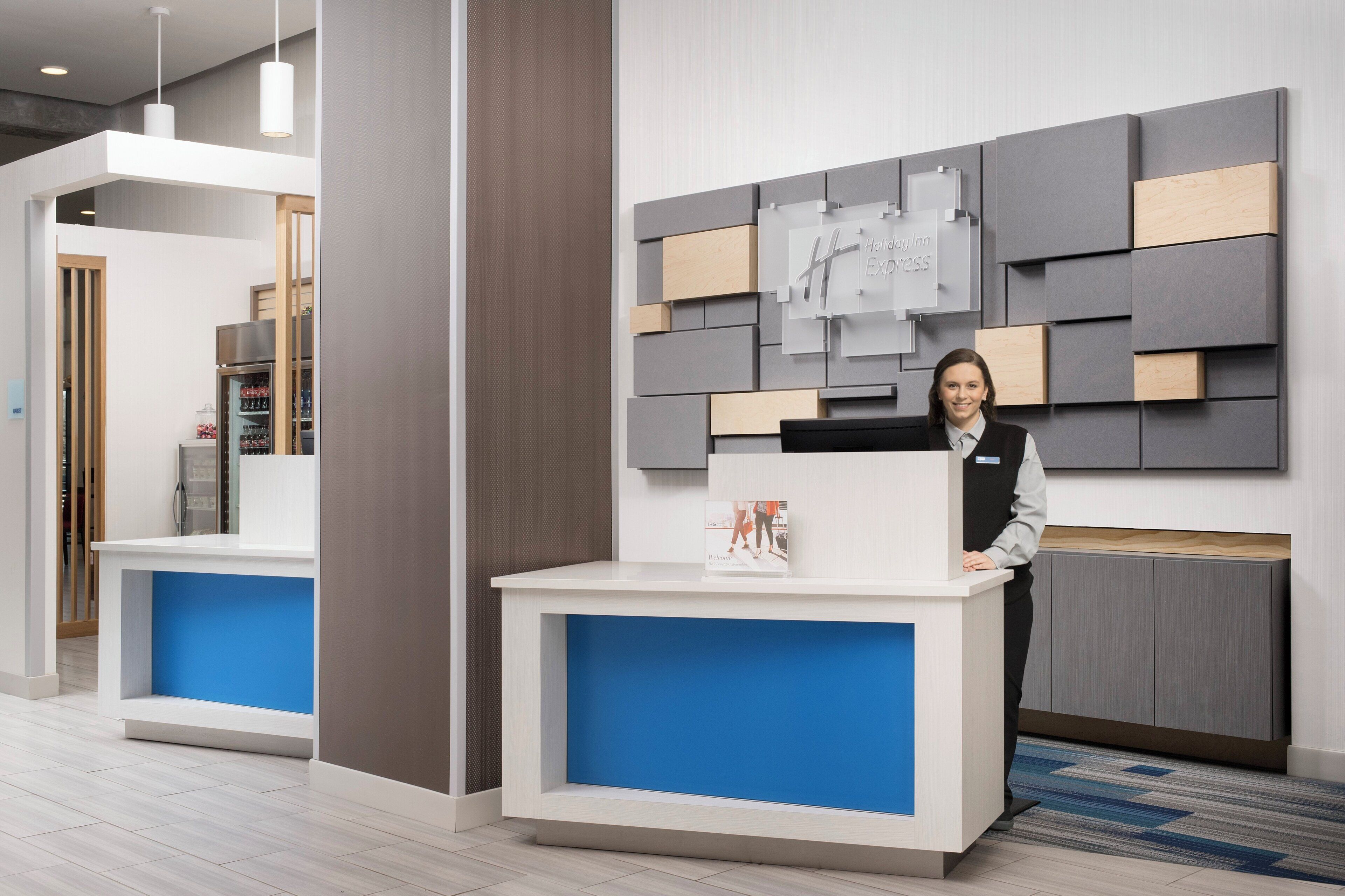 Una recepción con detalles azules, un letrero en la pared y un diseño interior moderno.