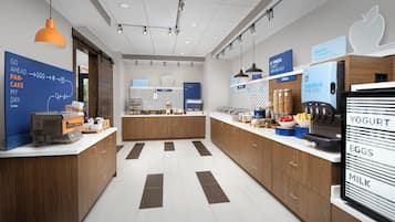 A modern kitchen area with a breakfast bar, a coffee machine, and a refrigerator with a yogurt and milk dispenser.