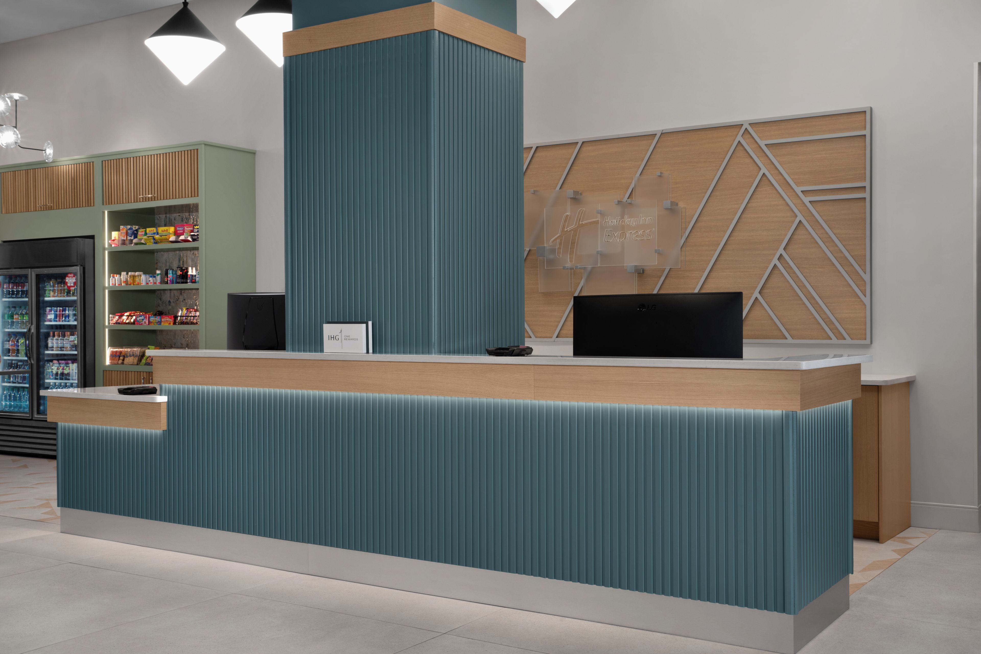 Een receptiebalie met een modern design, een digitaal scherm en een toonbank met een kaartlezer.