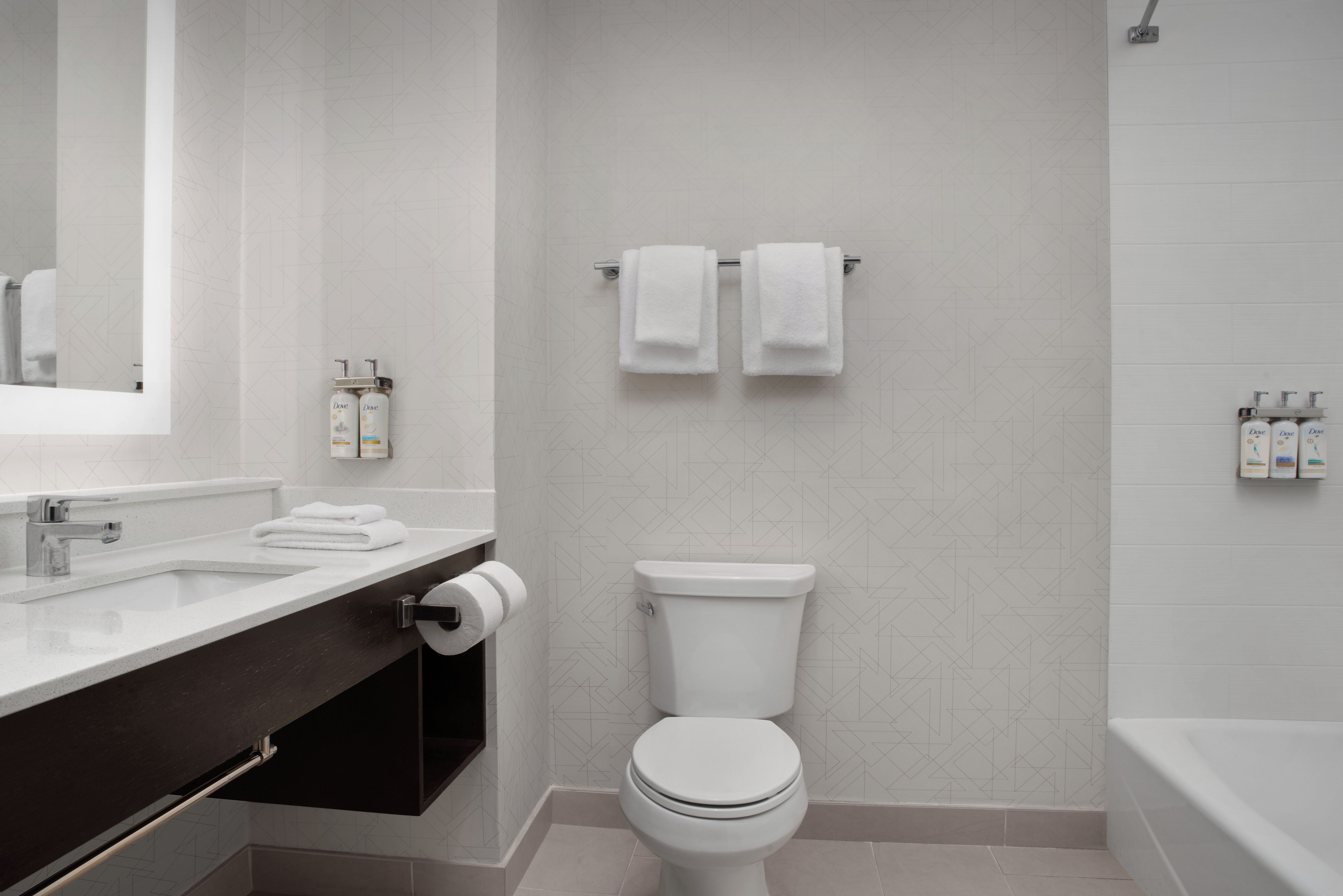 A modern bathroom with a white sink, a toilet, and a bathtub.
