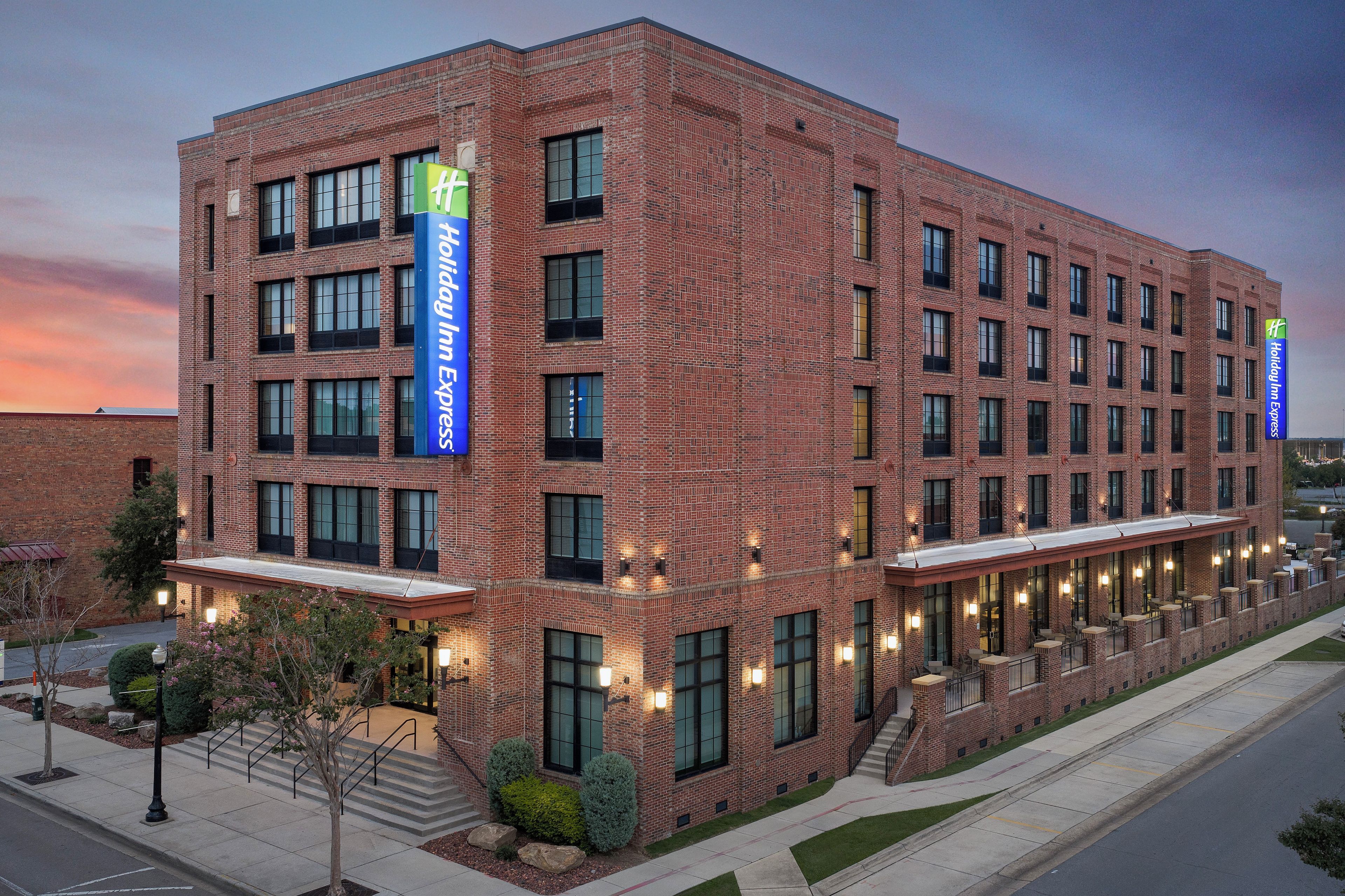 A multi-story brick building with a Holiday Inn Express sign, featuring a flat roof and a series of windows.