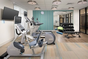 A fitness center with treadmills, an elliptical, a weight bench, and a rack of dumbbells. - Holiday Inn Express Pensacola Downtown by IHG (Pensacola)