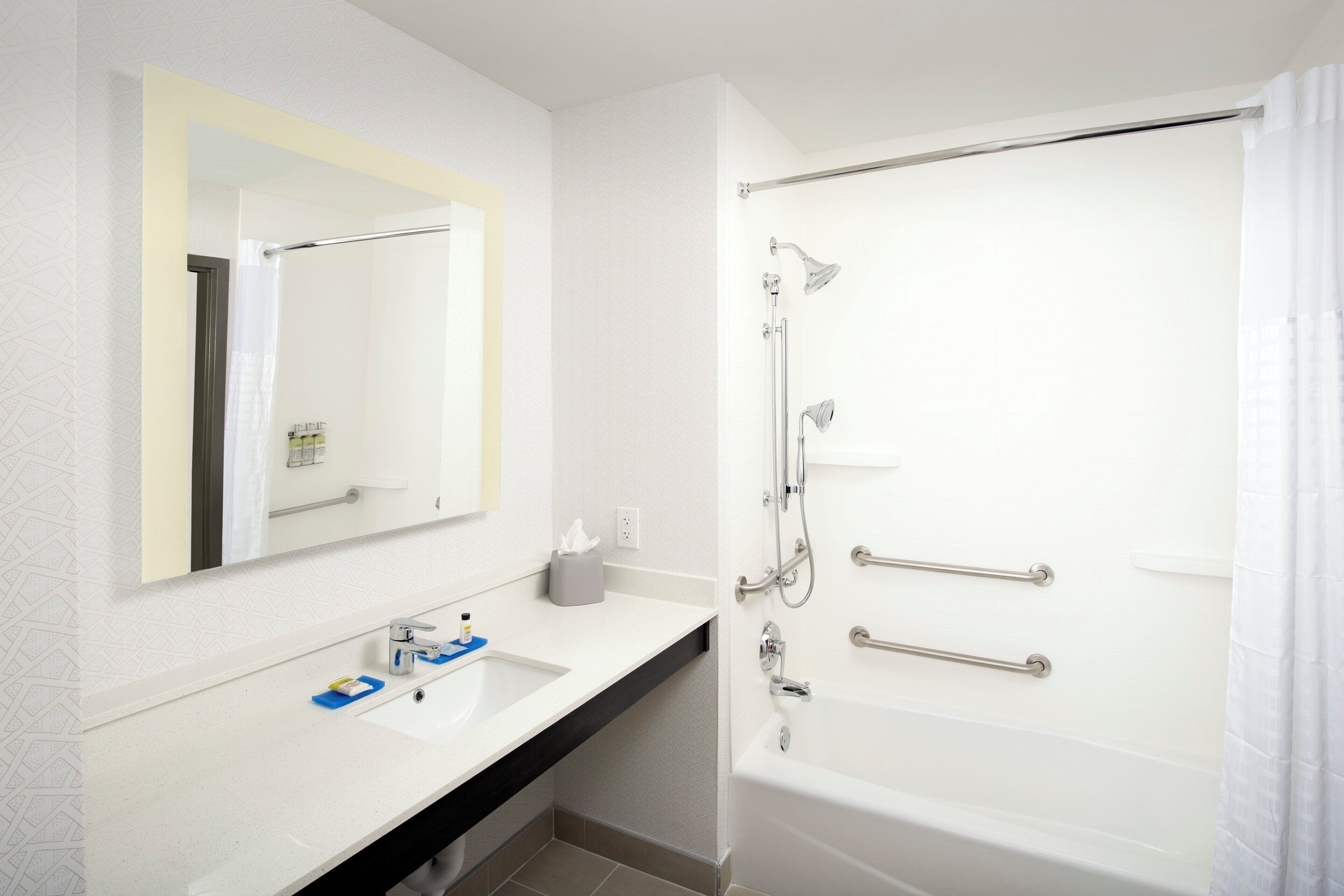 A bathroom with a white sink, mirror, and bathtub.