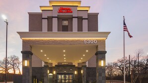 A hotel entrance with a sign reading "Hampton Inn & Suites" and the number "5300" above the door.