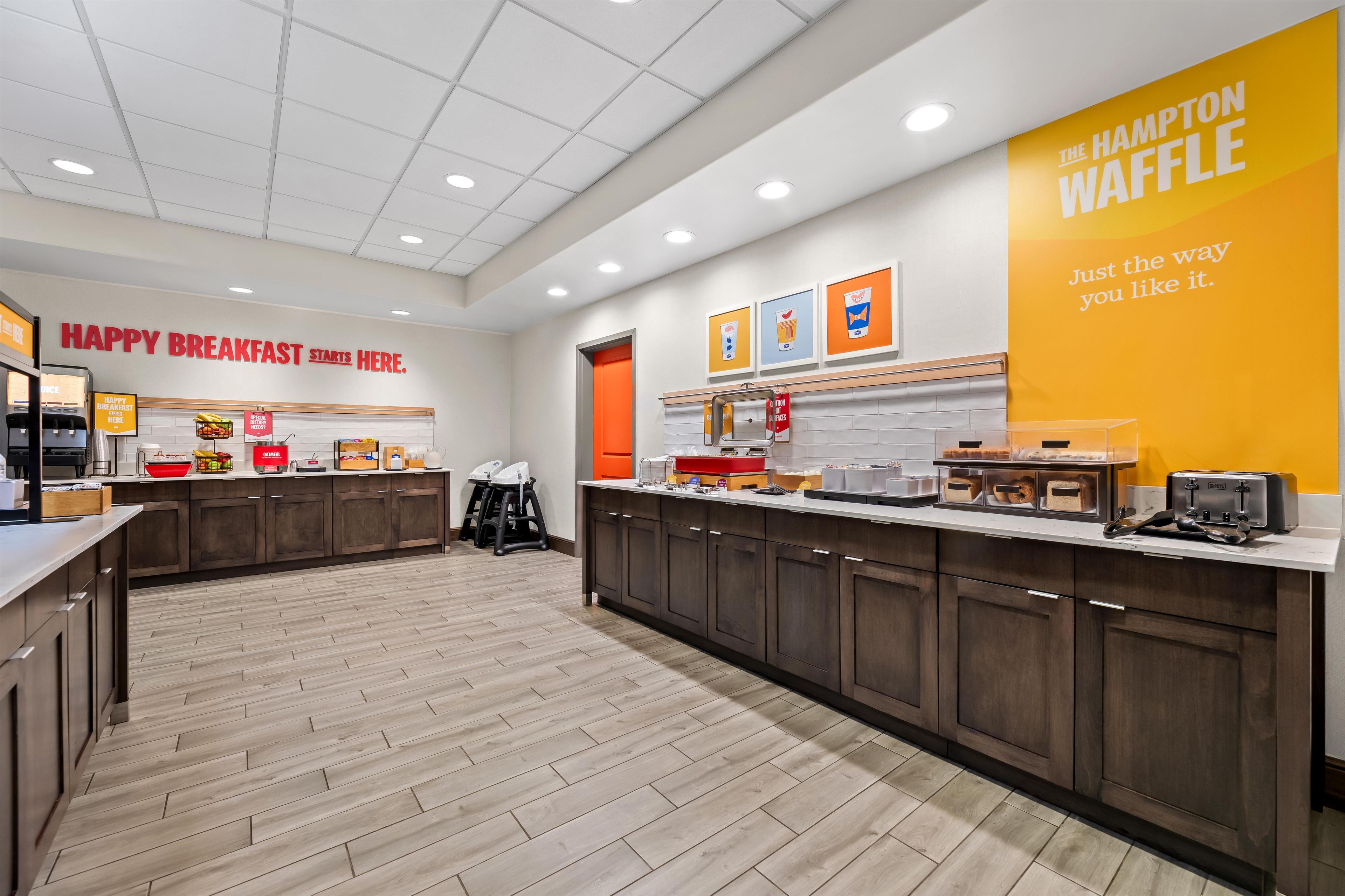 A breakfast area with a sign reading 'HAPPY BREAKFAST STARTS HERE.'