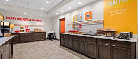 A breakfast area with a sign reading 'HAPPY BREAKFAST STARTS HERE.'