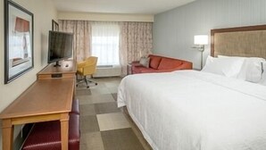 A hotel room with a bed, a desk with a chair, a television, and a window with curtains. - Hampton Inn Paragould (Paragould)