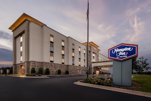 A Hampton Inn by Hilton hotel with a stone facade, multiple windows, and an American flag. - Hampton Inn Paragould (Paragould)