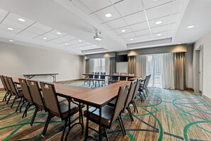 A conference room with a long table, chairs, a projector, and a large window with curtains. - Hampton Inn Paragould (Paragould)