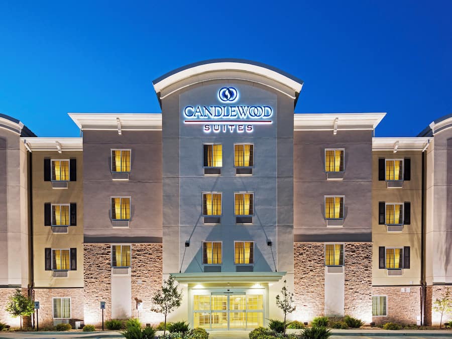 A hotel with a modern facade, multiple windows, and a sign indicating it offers suites.