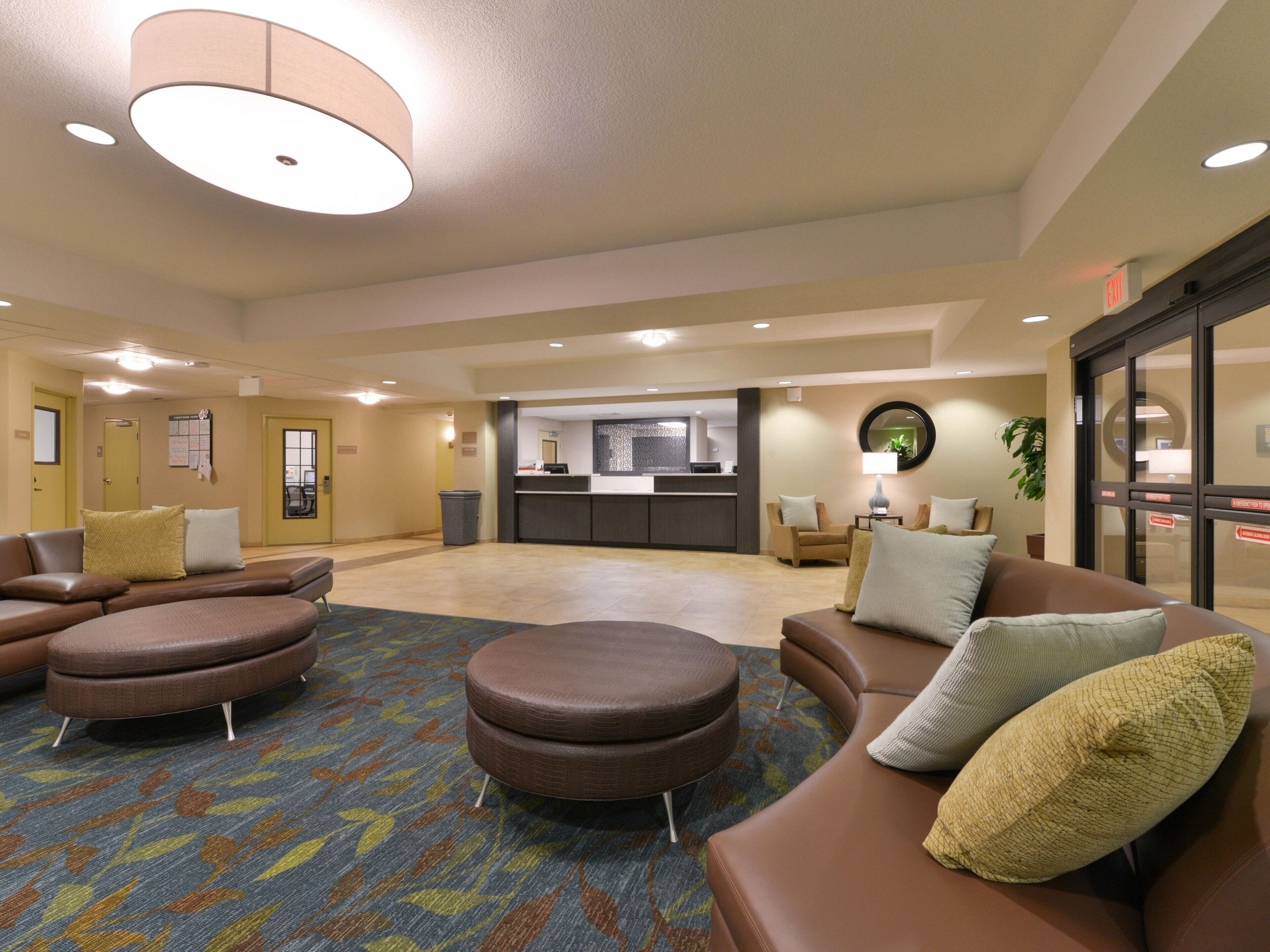 A spacious lobby with a reception desk, seating area, and a patterned carpet.