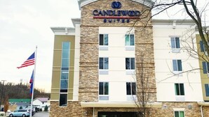 Um hotel com fachada de pedra, várias janelas e uma placa com a inscrição 'Candlewood Suites'.
