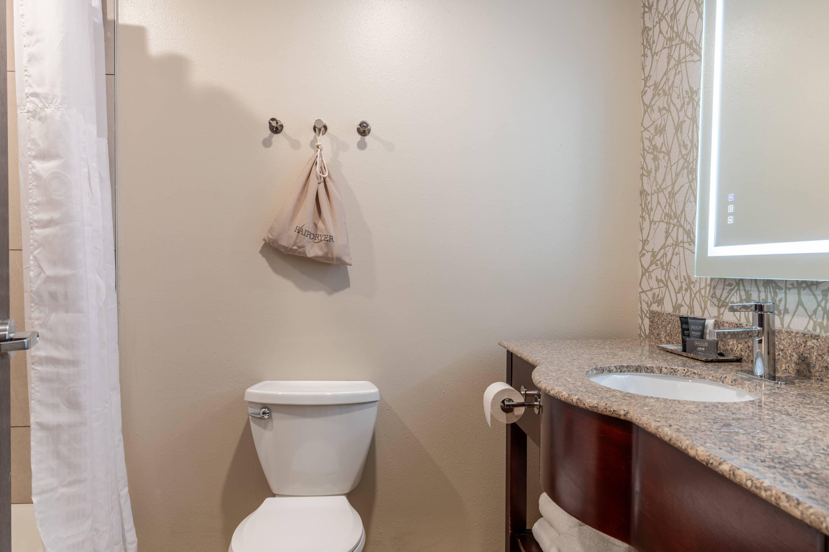 A bathroom with a toilet, a sink, and a shower curtain.