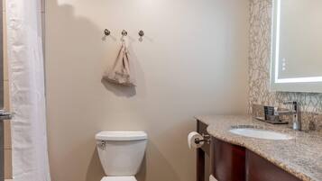 A bathroom with a toilet, a sink, and a shower curtain.