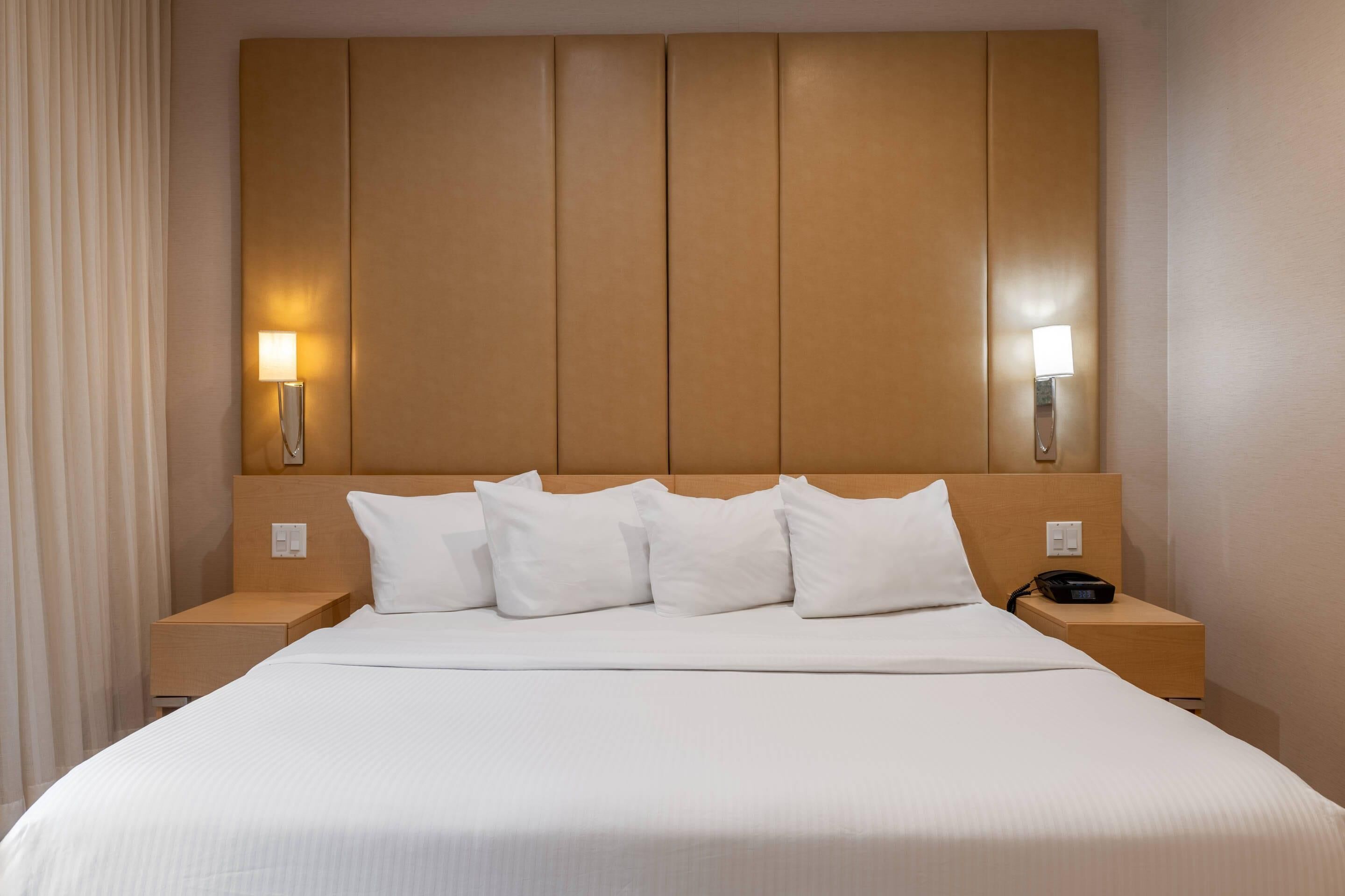 Una camera d'albergo con un letto grande, due comodini e lampade a parete.