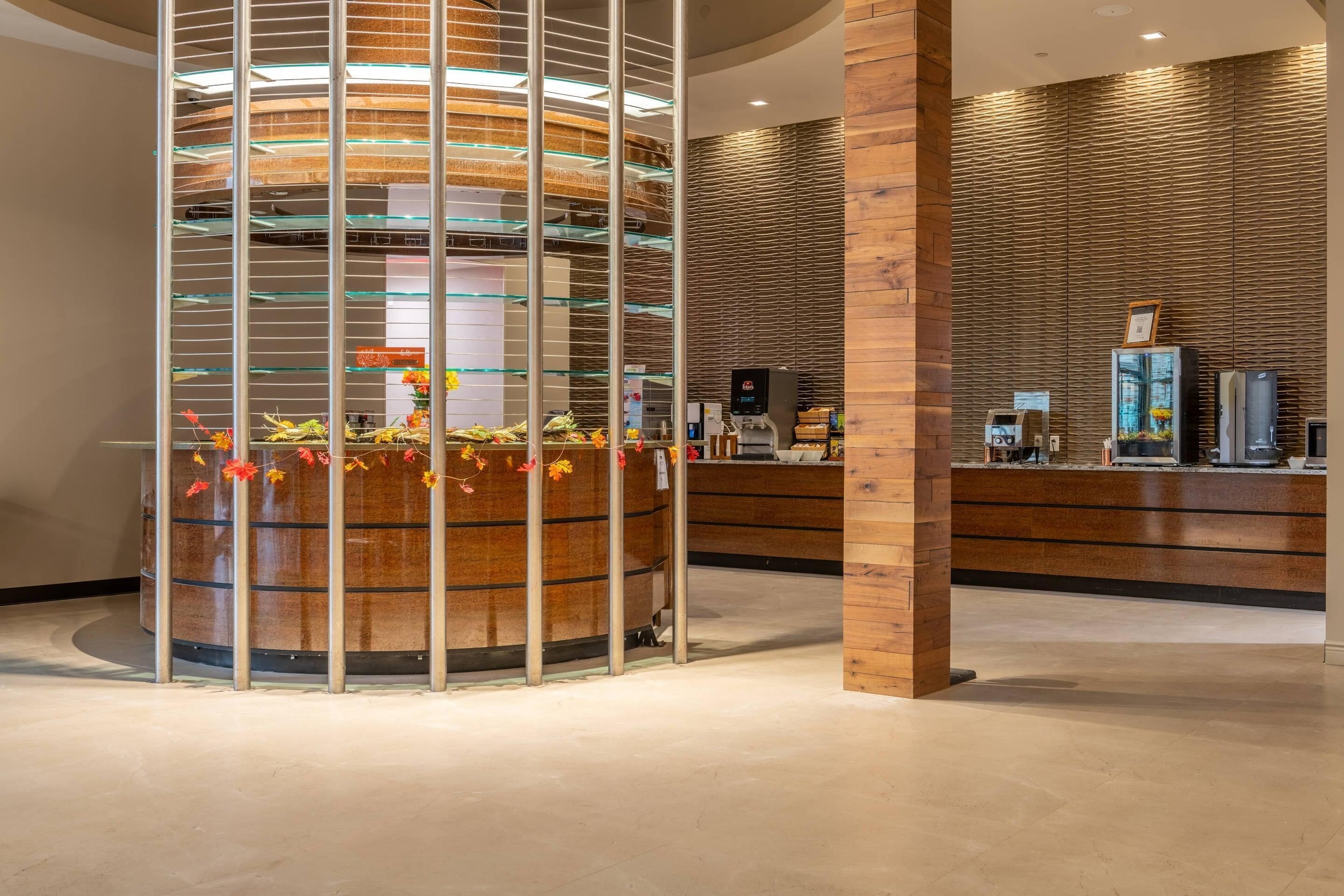 A reception area with a wooden reception desk, a glass display case, and a circular decorative structure with metal rods.
