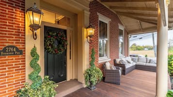 A brick house with a porch, a black door, and a sign reading "2764 Horseshoe Pike".