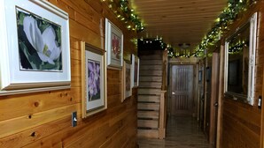 A wooden hallway with framed pictures on the walls, a staircase, and doors leading to other rooms. - Innisfaire (Traverse City)