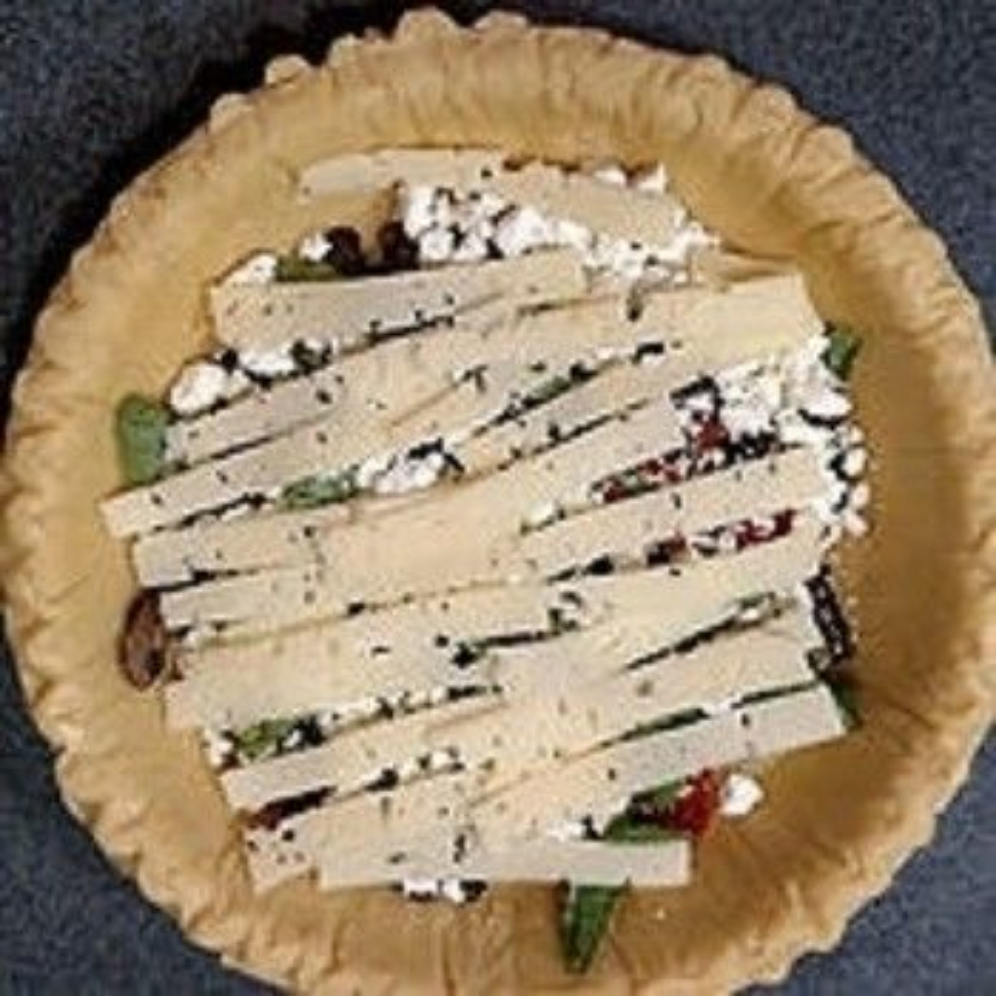 Un pastel con borde crujiente y relleno de verduras verdes y queso.