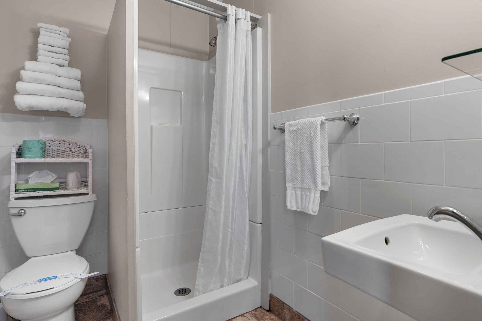A bathroom with a shower, toilet, and sink.