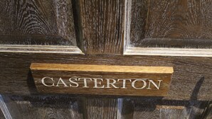A wooden nameplate with the name "CASTERTON" on a dark wooden door. - Red Dragon Inn (Carnforth)