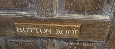 A wooden door with a sign that reads "HUTTON ROOF."