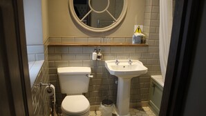 A small bathroom with a toilet, sink, and a mirror above the sink.