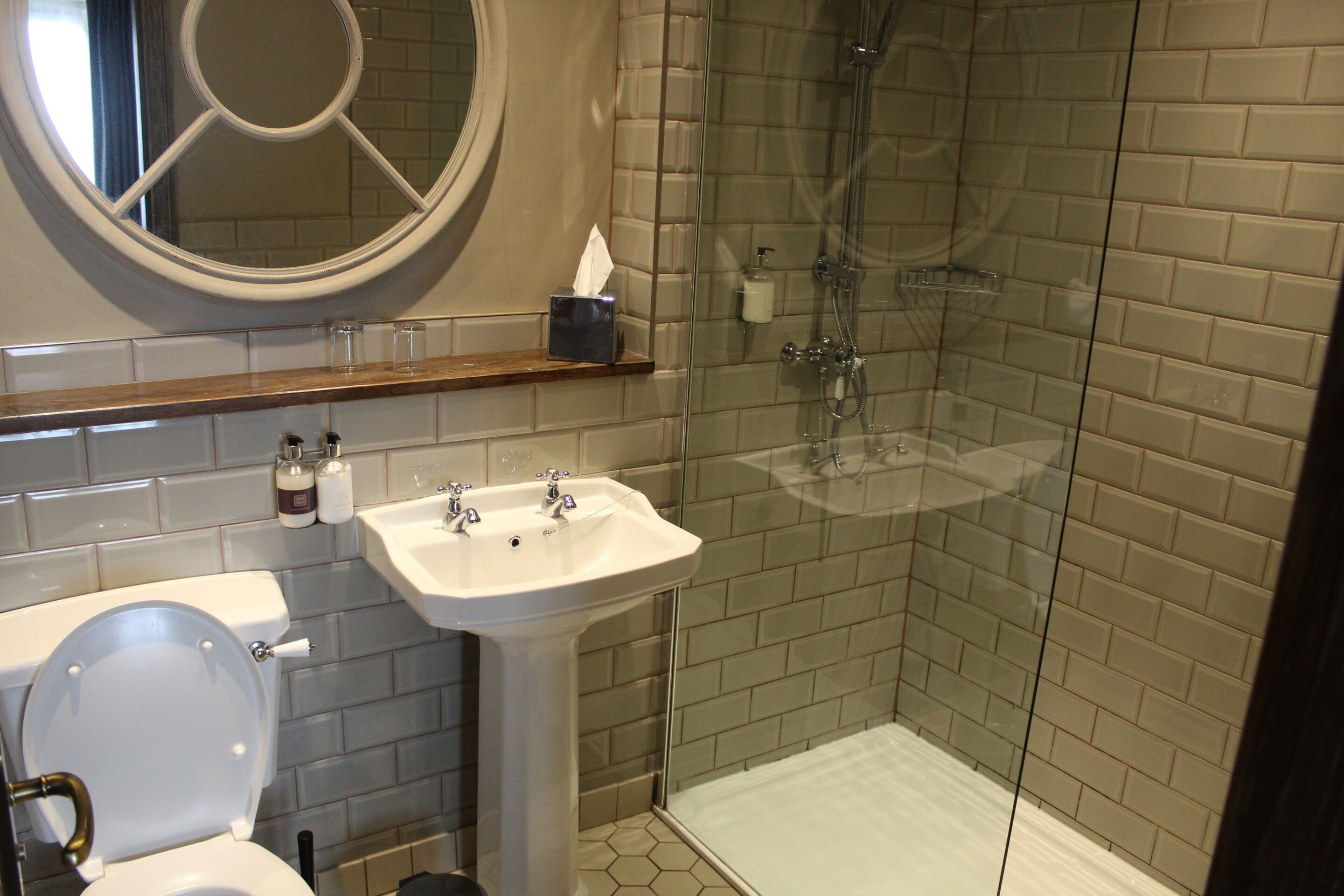 Un bagno con WC, lavandino e cabina doccia in vetro.
