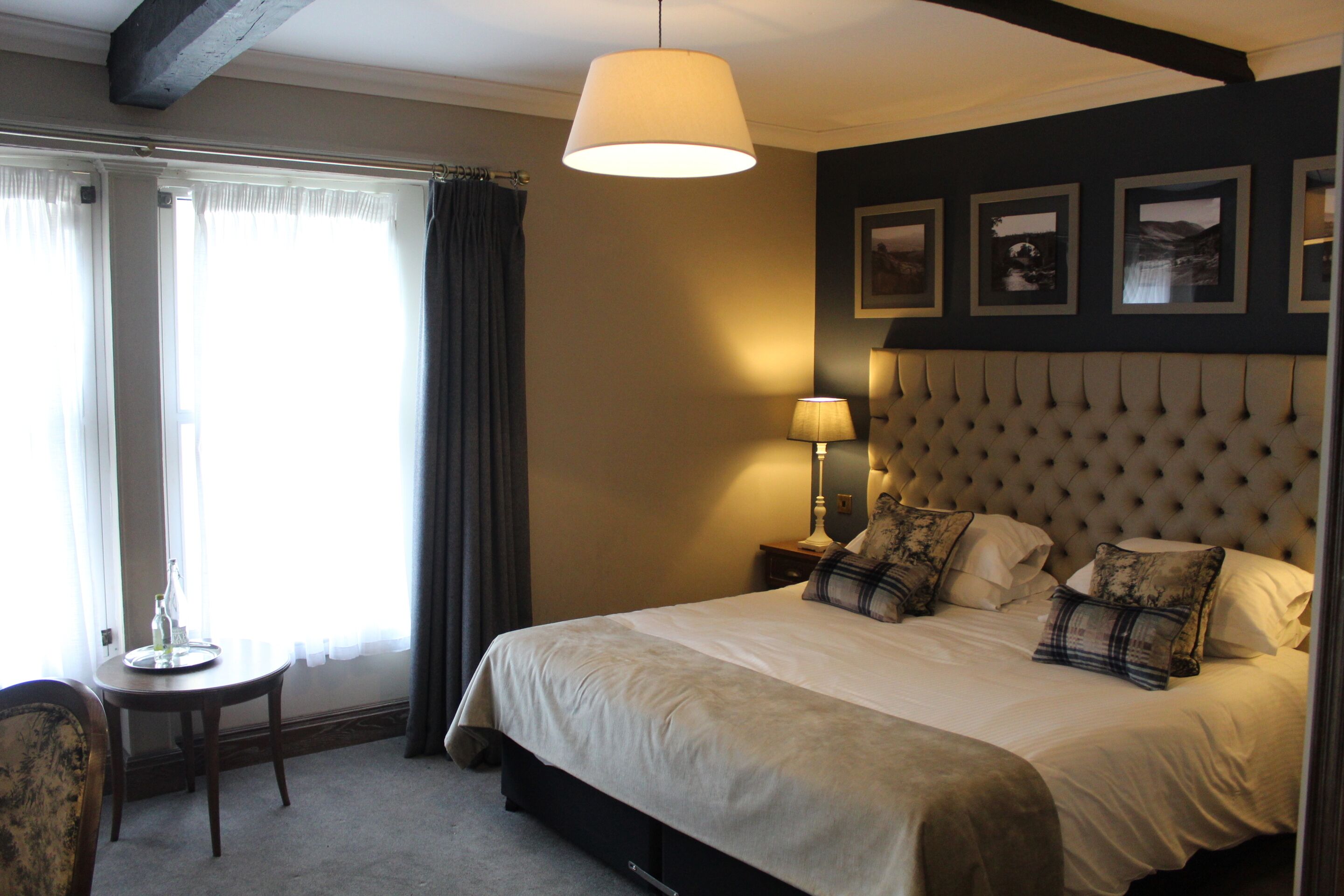 Een netjes ingerichte slaapkamer met een groot bed, een nachtkastje met lamp en een stoel.