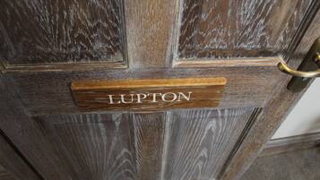 Una puerta de madera con un picaporte de latón y una placa que dice "LUPTON".