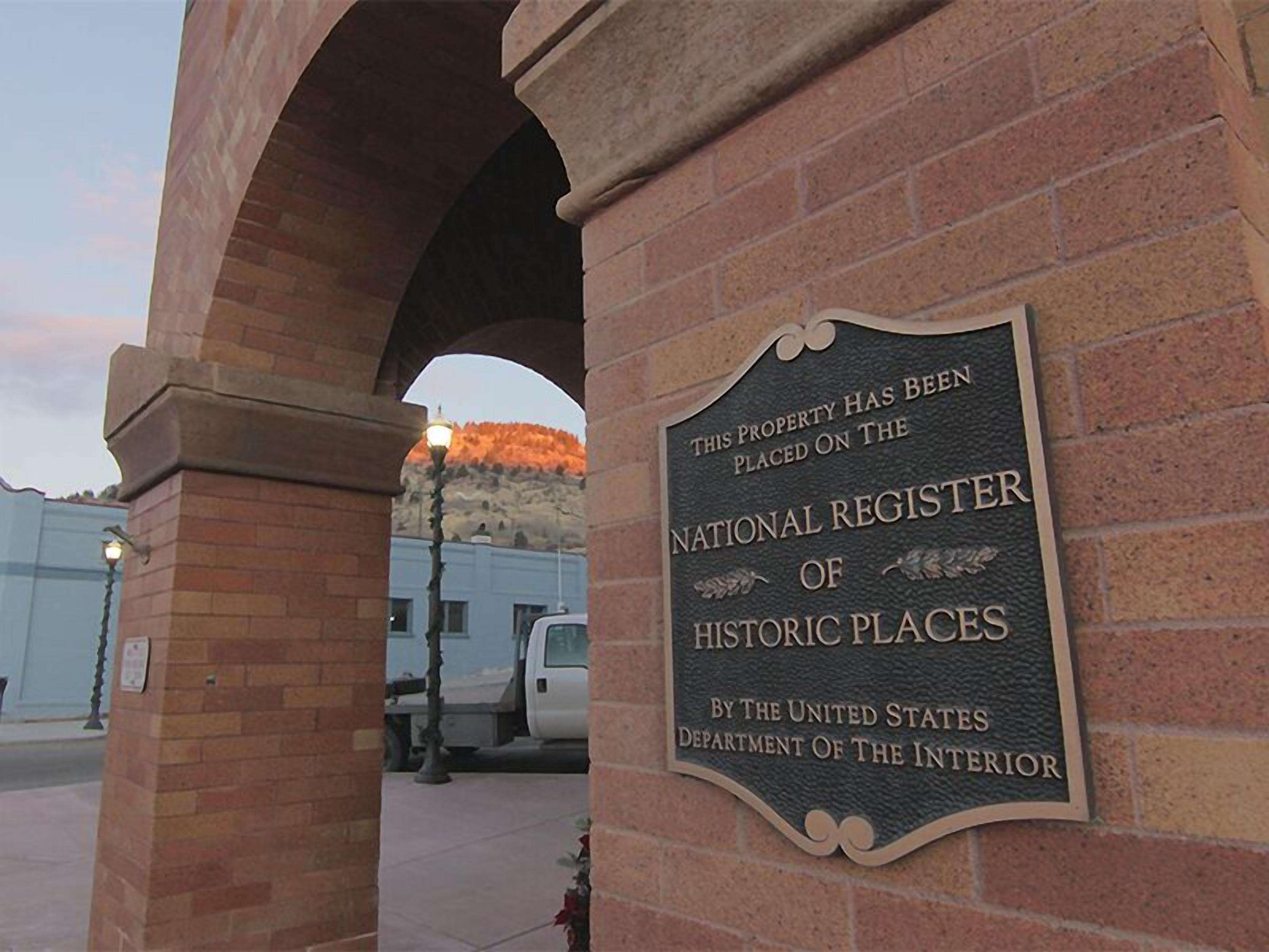 A brick archway with a plaque stating the property is on the National Register of Historic Places.