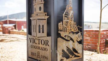 Een metalen bord met de tekst 'VICTOR COLORADO EST. 1894' en twee architecturale silhouetten.