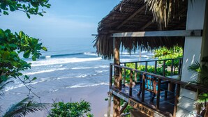 A beachfront property with a thatched roof structure, a sign indicating a resting area, and a view of the ocean. - Paraiso Escondido Hotel Villas & Resort (Teotepeque)