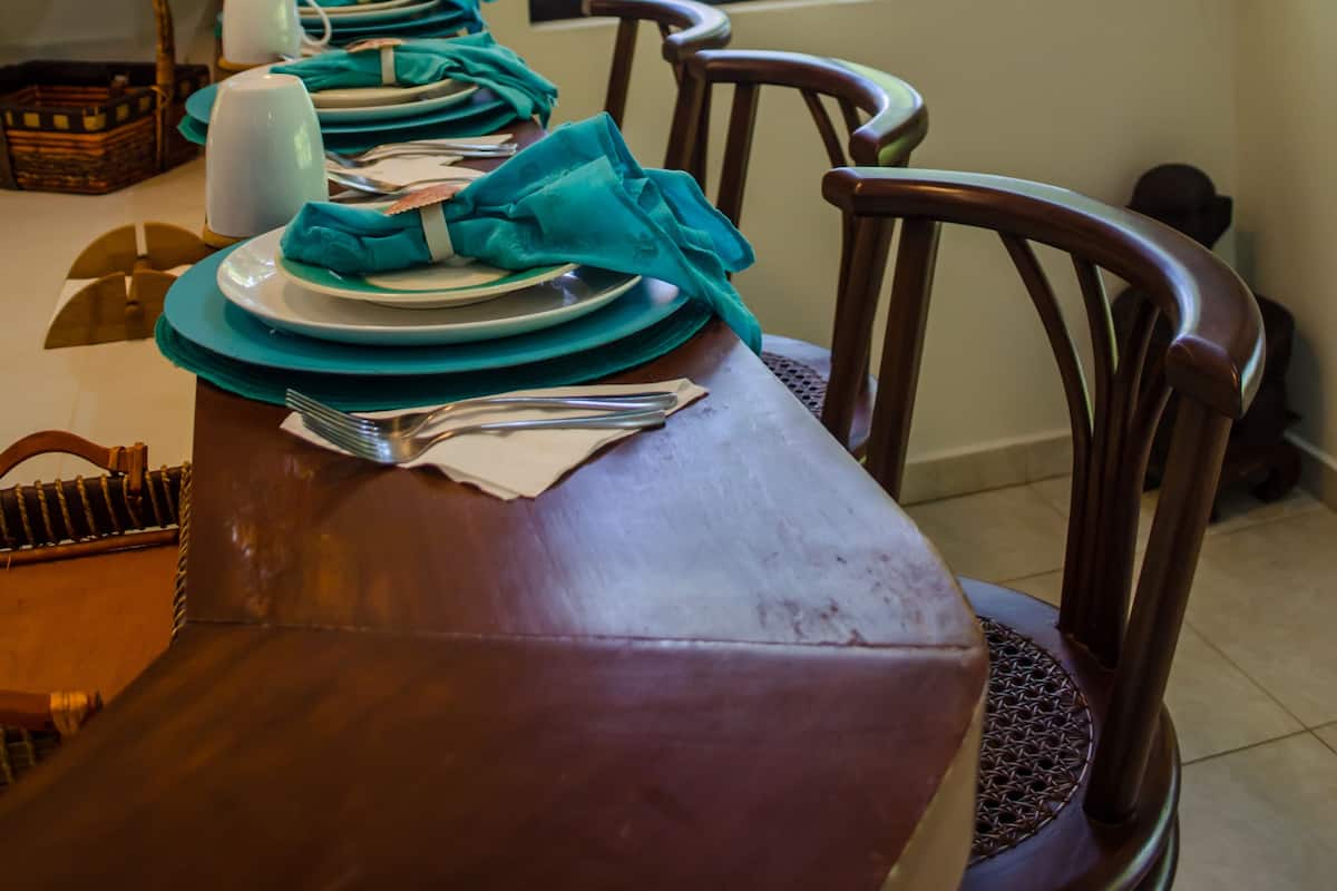 Una mesa de comedor dispuesta con platos, servilletas y una cesta.