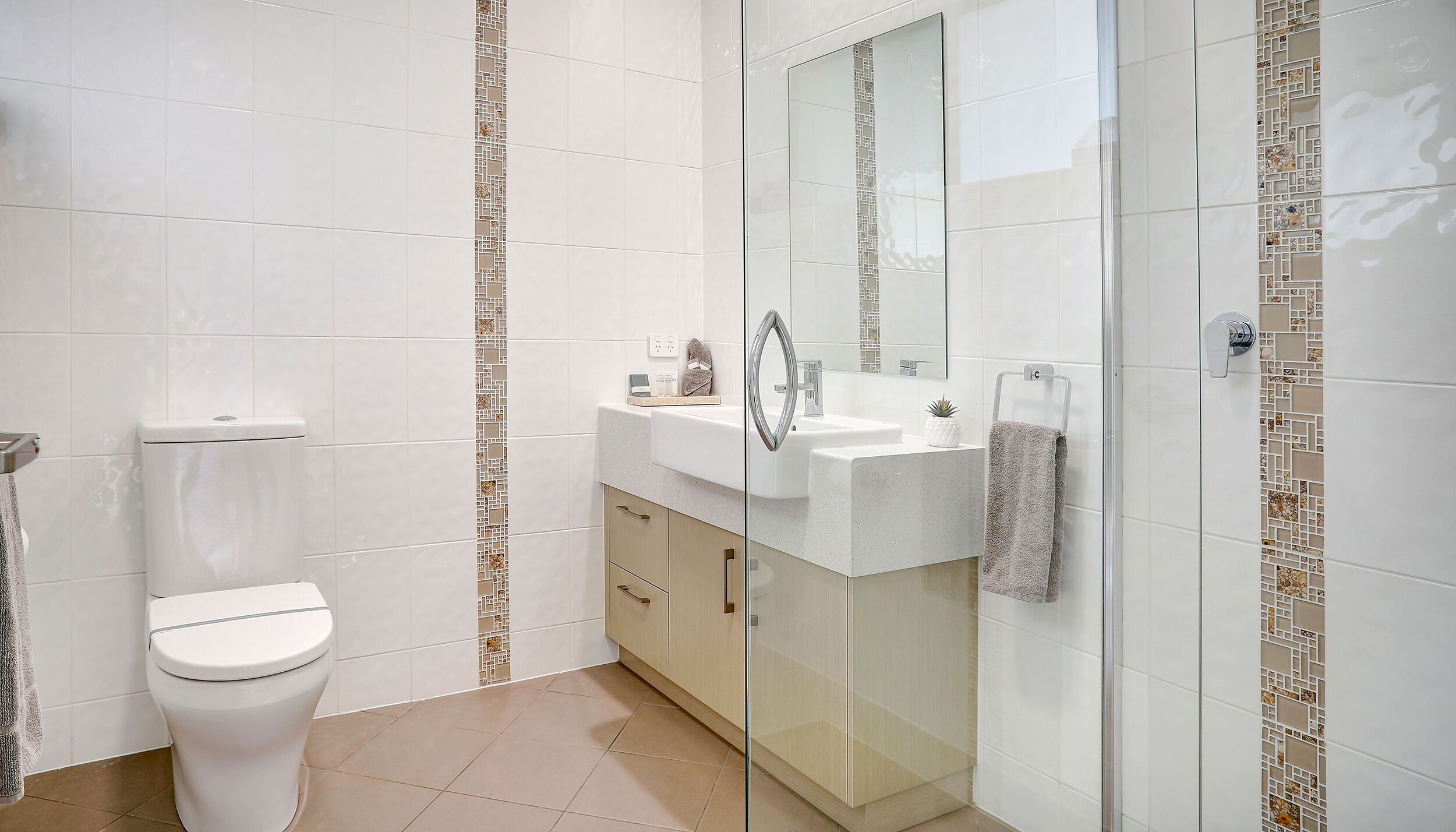 A modern bathroom with a toilet, sink, and shower.