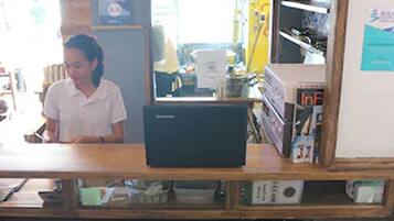 A reception desk with a computer, wooden cabinets, and a counter.
