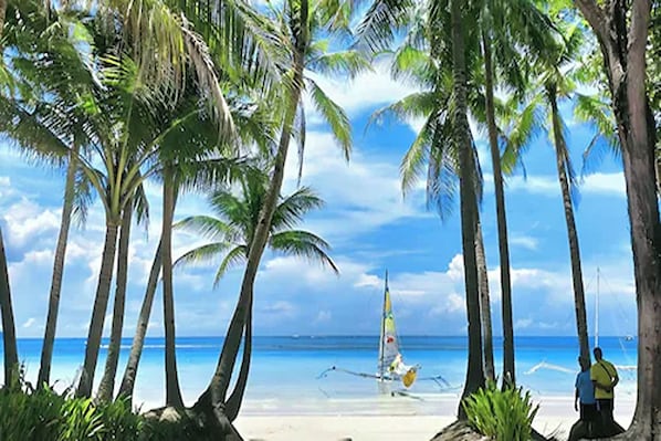 On the beach, white sand, sun loungers, beach umbrellas