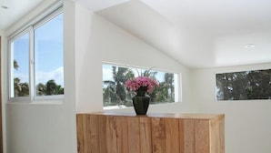 A room with a wooden cabinet, large windows, and a vase with flowers. - Zuzuni Boutique Hotel (Boracay Island)