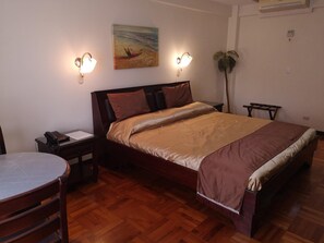 Ein Schlafzimmer mit einem hölzernen Bett, einem Nachttisch, einem Schreibtisch und einem Stuhl.