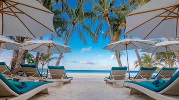 Grand kamer, uitzicht op zee (Beach Wing) | Strand | Aan het strand, wit zand, ligstoelen aan het strand, parasols