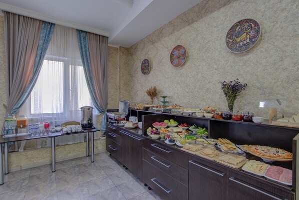 A buffet setup with various food items and a coffee station.