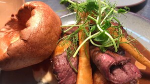 Une assiette de bœuf rôti, de carottes et de Yorkshire pudding.