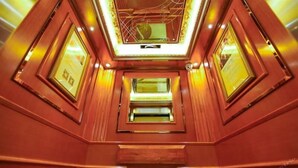 A hotel corridor with a modern design, featuring a central skylight and symmetrical doorways. - Vienna International Hotel (Changsha)