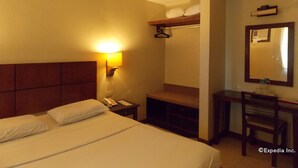 A hotel room with a bed, bedside table, lamp, mirror, and a desk with a chair. - Mo2 Days Inn (Bacolod)