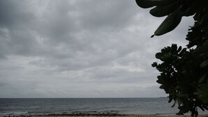 Una platja de pedres i un cel nuvolós.