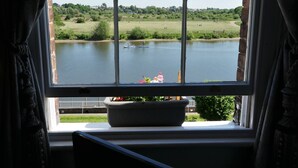 A window with a view of a lake, a grassy field, and a few boats. - Rondeva (Chester)