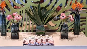 A display table with vases of flowers and magazines.
