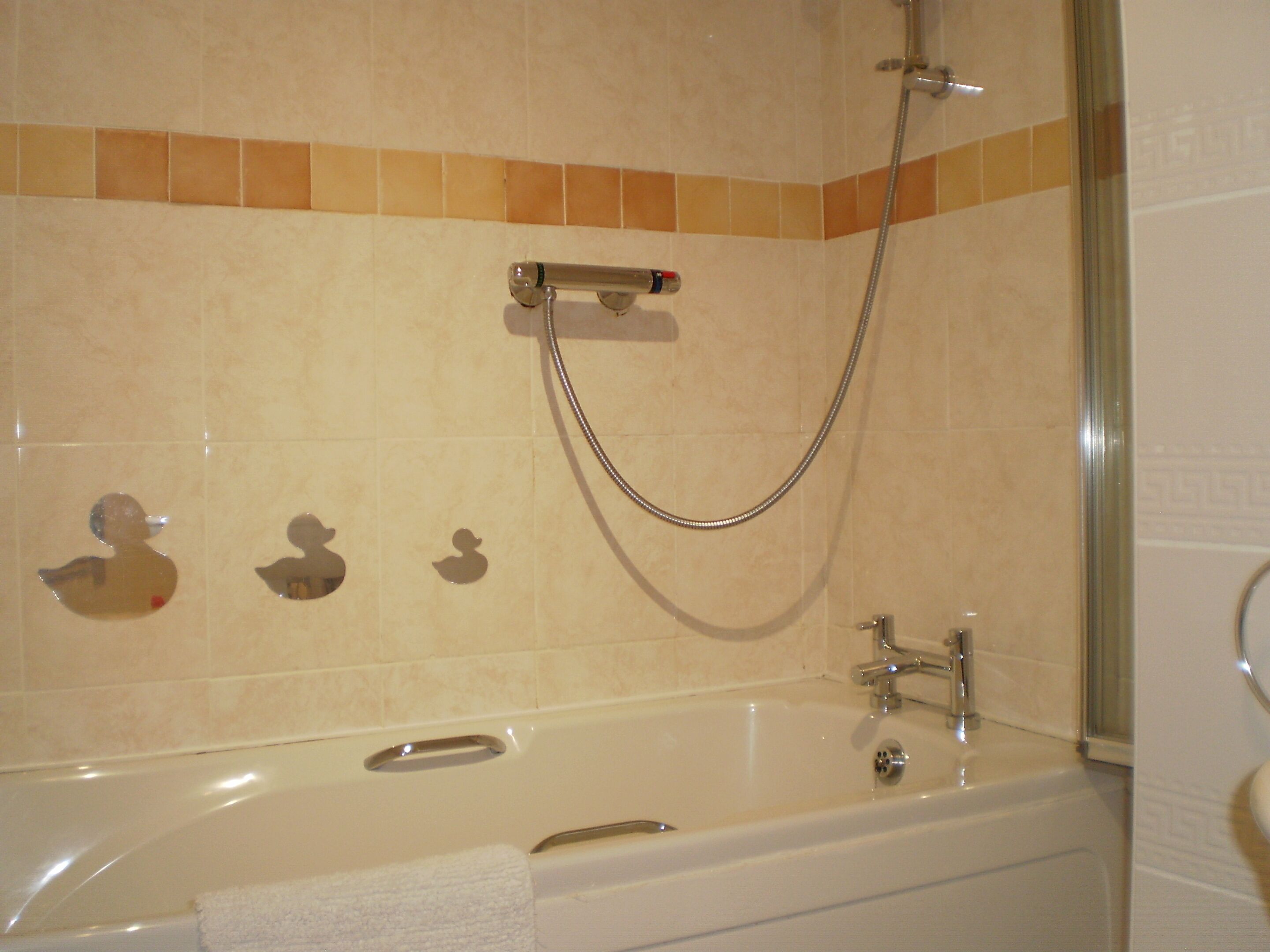 A bathroom with a bathtub, a shower, and a towel rack.