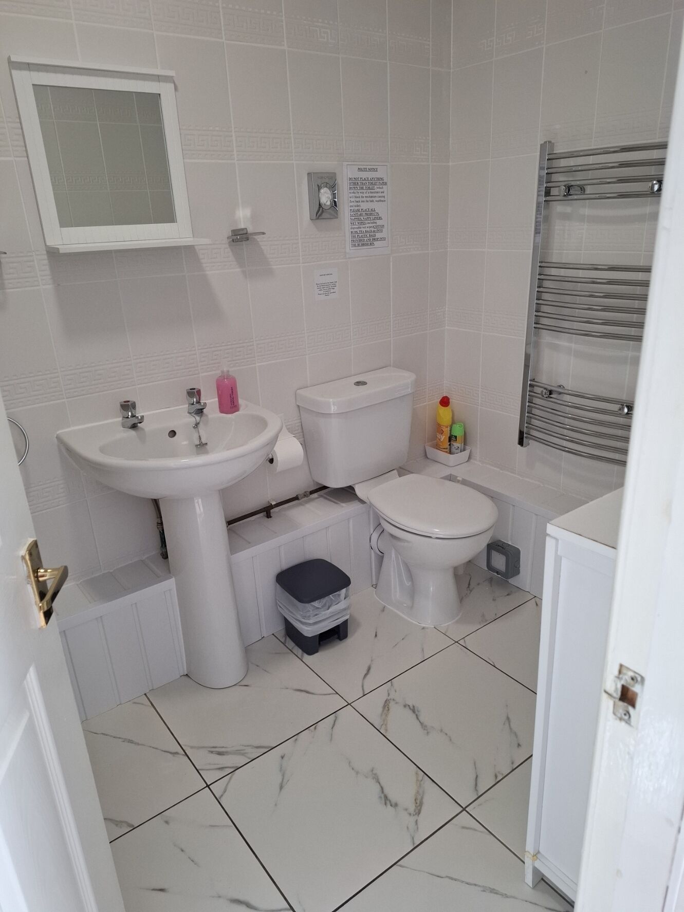 Un bagno con lavandino, WC e bidet. È presente un cestino e un portasacchi.